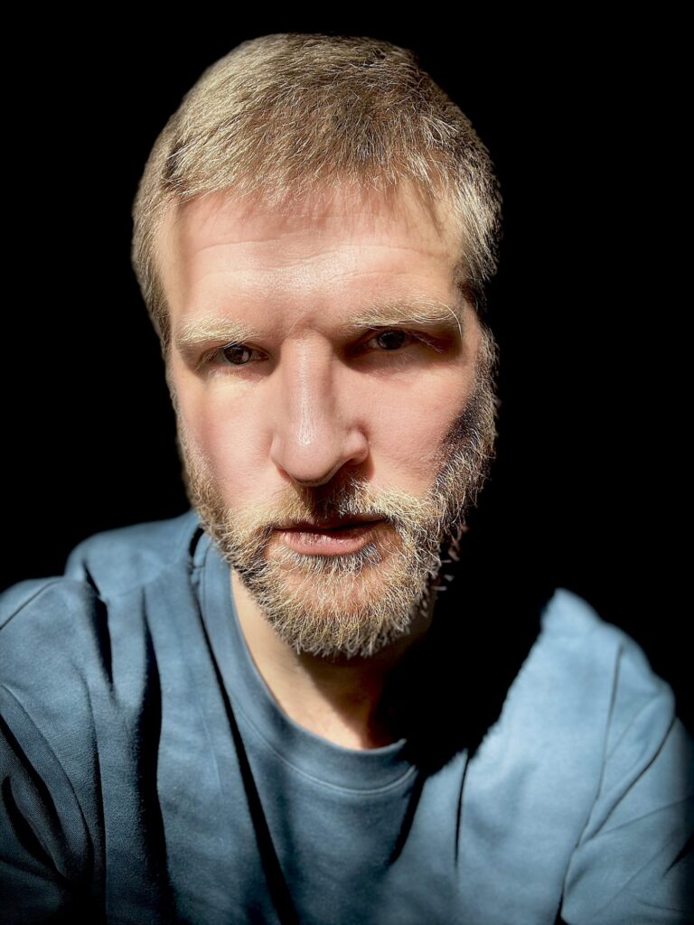Portrait barbu sur fond noir, chemise bleue